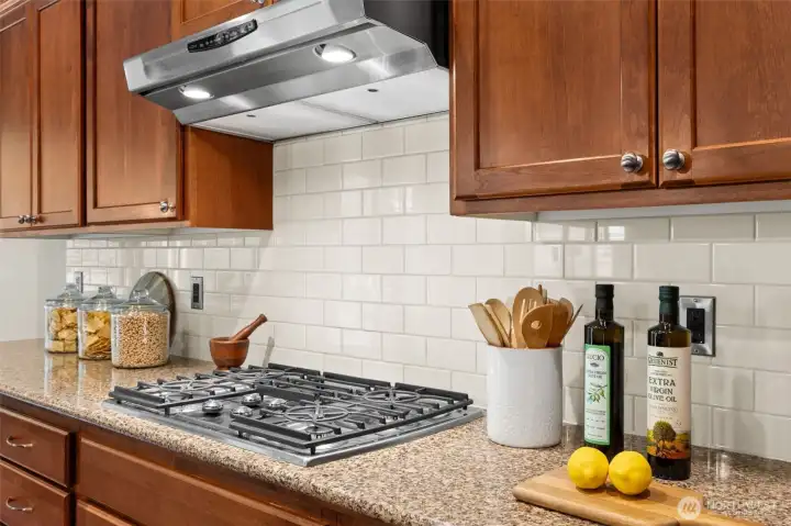 Gas range with hooded vent and subway tile backsplash