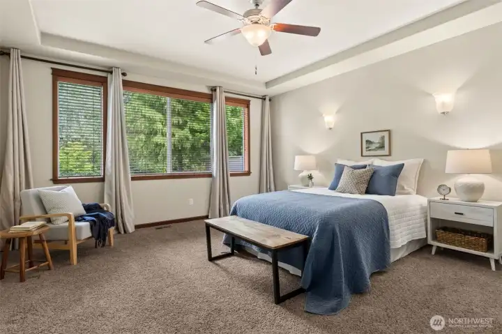 Spacious primary bedroom with views out to wetland buffer area.