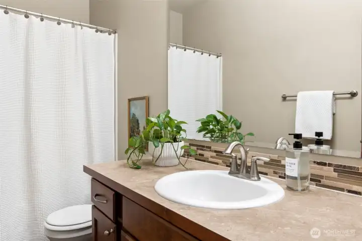 One of 3 full bathrooms is in between 2 bedrooms on the main floor