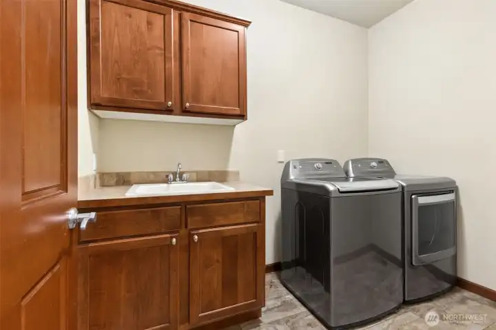 Spacious laundry room with sink has new floors