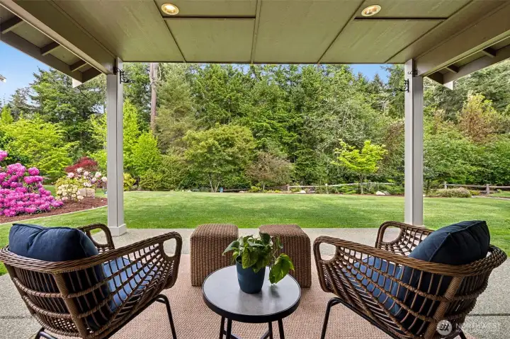 Covered pation with views of professionally landscaped yard and wetland buffer area.