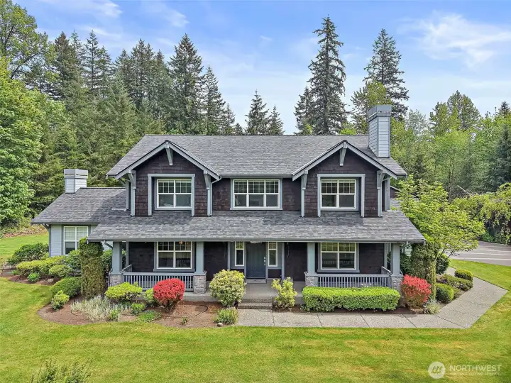 Front exterior of the luxury Maple Valley retreat, set against a private, tree-lined backdrop with manicured landscaping and a covered front porch. Front exterior of the luxury Maple Valley retreat, set against a private, tree-lined backdrop with manicured landscaping and a covered front porch.
