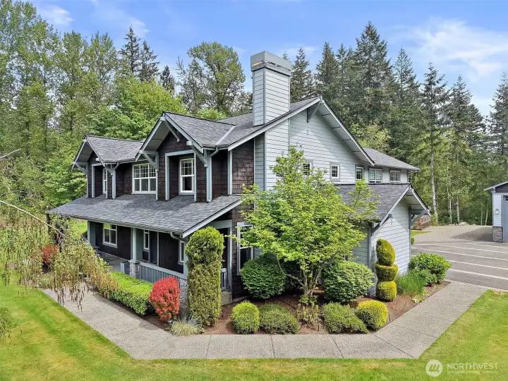 Front exterior of the luxury Maple Valley retreat, set against a private, tree-lined backdrop with manicured landscaping and a covered front porch. Front exterior of the luxury Maple Valley retreat, set against a private, tree-lined backdrop with manicured landscaping and a covered front porch.
