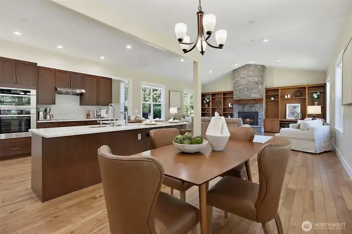 Bright eating area off the kitchen with large windows, warm wood flooring, upgraded lighting, and views toward the covered patio and fenced garden. Bright eating area off the kitchen with large windows, warm wood flooring, upgraded lighting, and views toward the covered patio and fenced garden.
