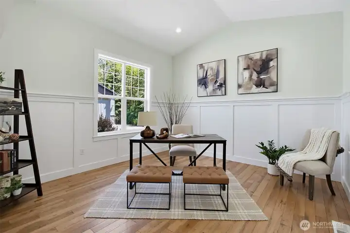 Main-level den with warm wood flooring, large window, and flexible space for work, reading, or quiet use. Main-level den with warm wood flooring, large window, and flexible space for work, reading, or quiet use.