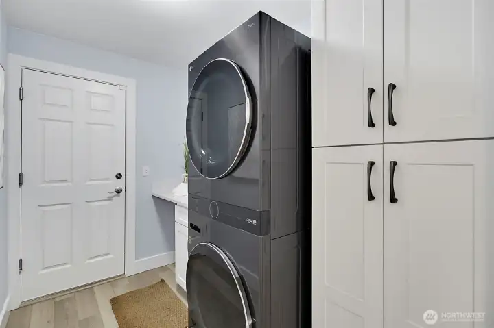 Laundry room with new LG stacking washer and dryer, new soft-close cabinets, and new quartz countertops. Laundry room with new LG stacking washer and dryer, new soft-close cabinets, and new quartz countertops.