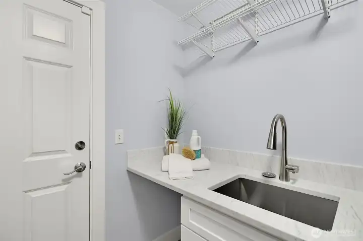 Updated laundry sink area with new quartz countertop, cabinetry, and hanging space. Updated laundry sink area with new quartz countertop, cabinetry, and hanging space.