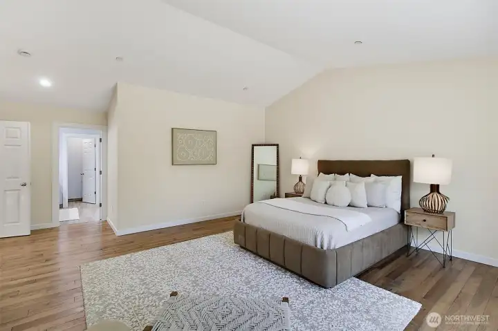 Primary bedroom with vaulted ceiling, fresh finishes, and room for a comfortable sitting area. Primary bedroom with vaulted ceiling, fresh finishes, and room for a comfortable sitting area.