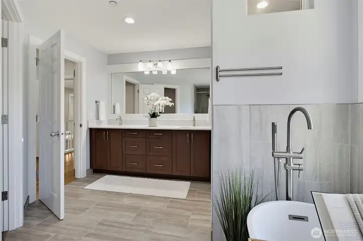 Primary bath with a slipper tub, large window views, new tile flooring, quartz countertops, and solid wood cabinetry. Primary bath with a slipper tub, large window views, new tile flooring, quartz countertops, and solid wood cabinetry.