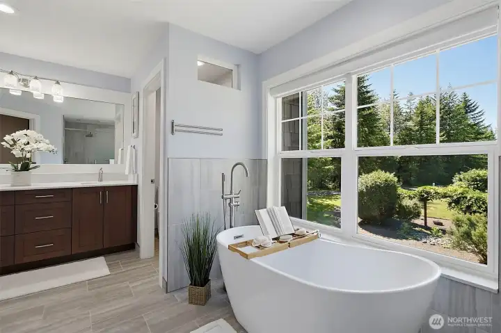 Primary bath with a slipper tub, large window views, new tile flooring, quartz countertops, and solid wood cabinetry. Primary bath with a slipper tub, large window views, new tile flooring, quartz countertops, and solid wood cabinetry.