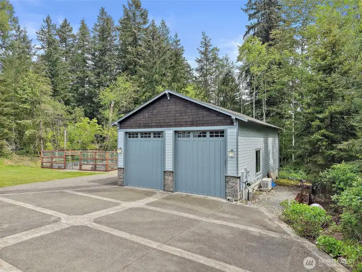 Large two-story shop with oversized doors, paved access, and a private wooded backdrop. Large two-story shop with oversized doors, paved access, and a private wooded backdrop.