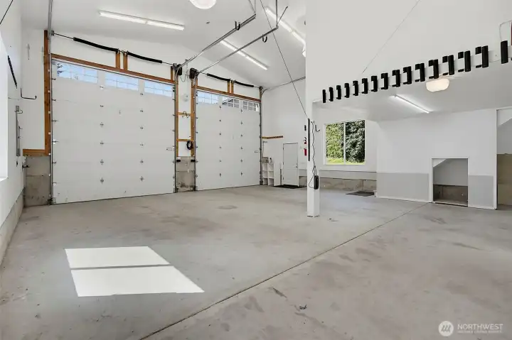 Spacious shop interior with tall ceilings, large doors, and flexible space for storage, tools, and work areas. Spacious shop interior with tall ceilings, large doors, and flexible space for storage, tools, and work areas.