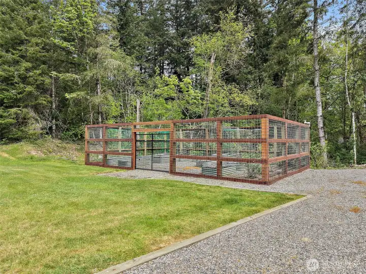 Elk fenced irrigated garden with raised beds, open lawn, and a peaceful wooded backdrop. Elk fenced irrigated garden with raised beds, open lawn, and a peaceful wooded backdrop.