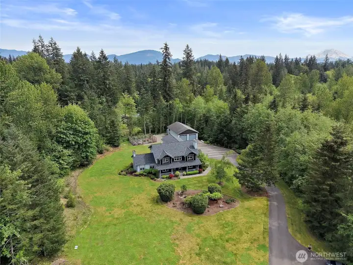 Aerial view of the private 3-acre setting with the home, shop, garden, and surrounding trees. Aerial view of the private 3-acre setting with the home, shop, garden, and surrounding trees.