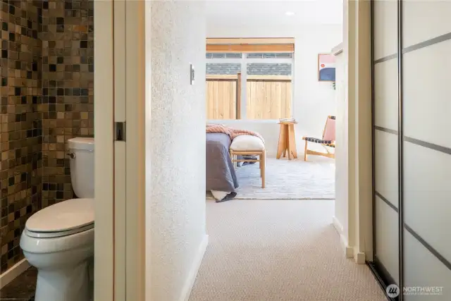 This view is from the hallway to the "primary suite" - this section of the house has a pocket door that can close off the bathroom with its heated floors and jetted tub, the big closet on the right, and the bedroom.