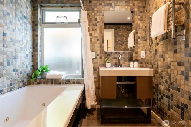 The primary suite bathroom - with jetted tub, heated tile floor, and heated towel rack