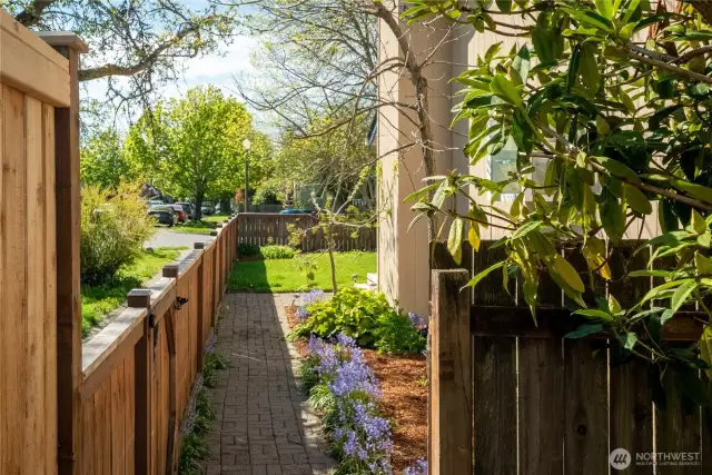 Along the south side of the house is a brick walkway and flower beds...continuing on into the front yard where there are several roses!