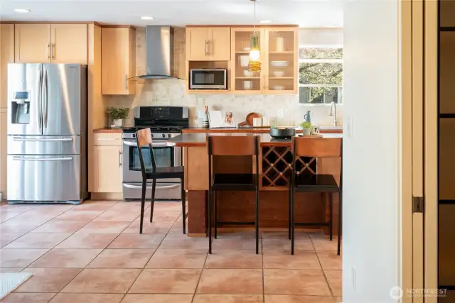 Stainless steel appliances, tile backsplash, and a built-in wine drawer