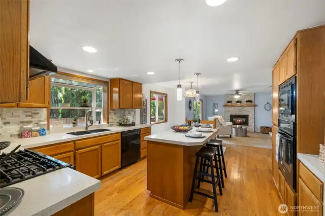 Oak cabinets and hardwood floors. Quartz counter tops and tile backsplash. Gas cooking, two ovens and built in microwave.