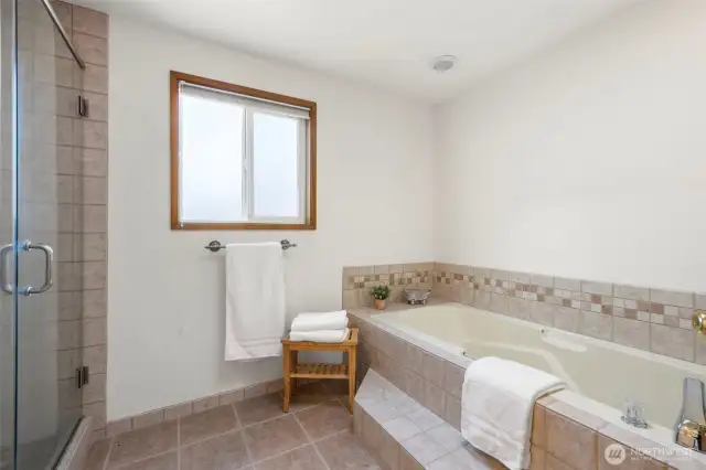 Tile floors, shower surround and soaking tub in primary bath.