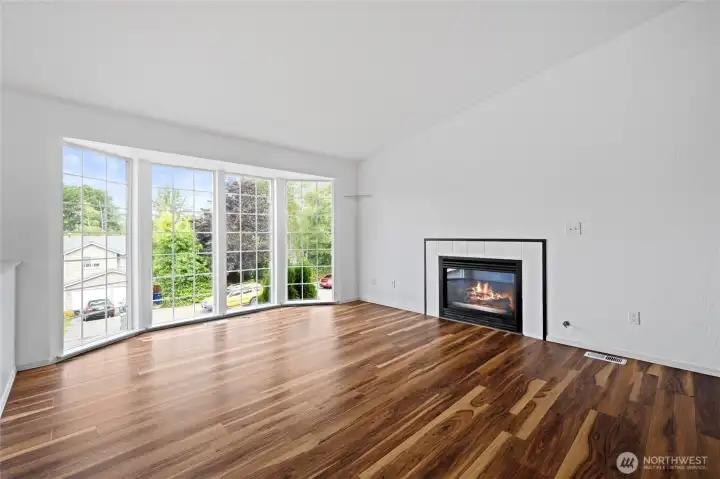 Light filled living room with gas fireplace.