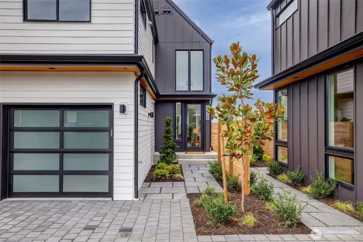 Secluded front entry with attached one car garage.