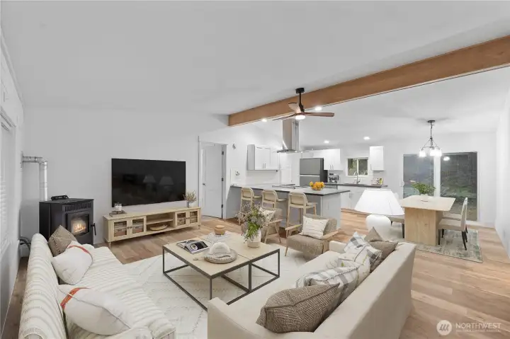 The staged living room demonstrates how spacious and comfortable this open-concept layout can be. The wood-burning stove anchors the room with a cozy touch, while the large seating area highlights options for arranging furniture. The space blends seamlessly into the kitchen and dining area, giving buyers a clear sense of how well the great-room layout lives.