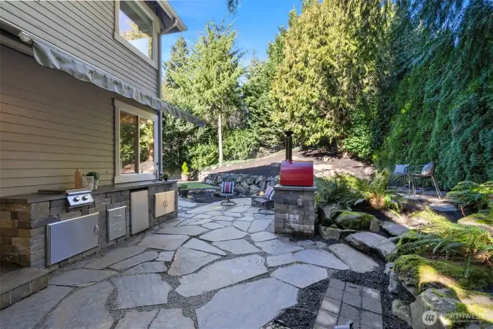 Outdoor kitchen with industrial pizza oven to make your yard parties sizzle.