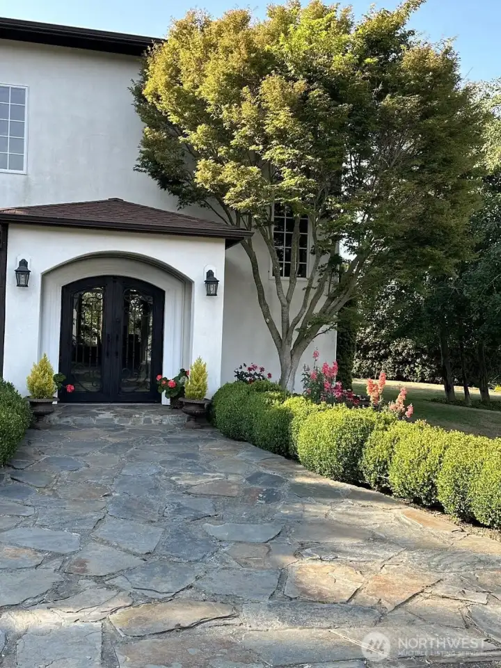 Flagstone walkway leads to the custom iron doors at the entry
