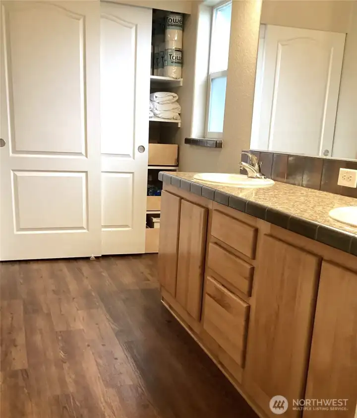 Directly off the bedroom, the primary bathroom showcases double sinks, laminate flooring and an oversized storage closet—ideal for linens and everyday necessities. Directly off the bedroom, the primary bathroom showcases double sinks, laminate flooring and an oversized storage closet—ideal for linens and everyday necessities.