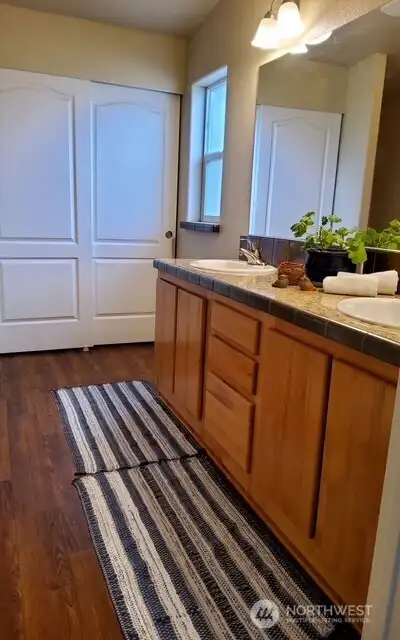 Directly off the bedroom, the primary bathroom showcases double sinks, laminate  flooring and an oversized storage closet—ideal for linens and everyday necessities.