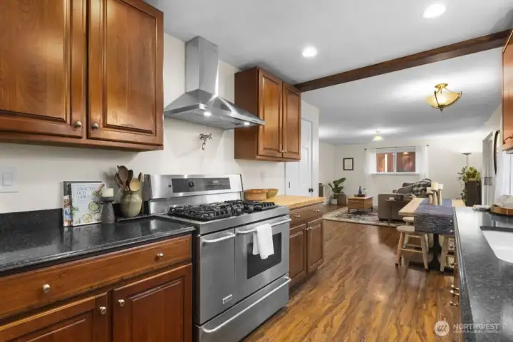 Three storage closets provide ample pantry and storage space in this kitchen. The door to the first is visible just beyond the butcher block counter. The second and third closet are in the walkway between the kitchen and entry.