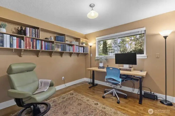 Bedroom 1 is currently being used as a home office. Built-in shelving on the far wall and inside the closet make storage simple.