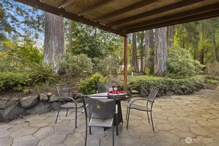A covered patio is a must in the PNW. Mature trees and landscaping turn the backyard into a private retreat.