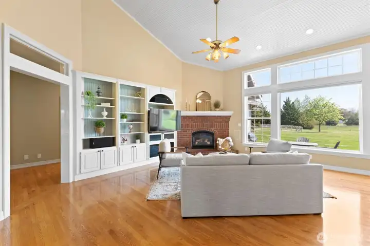 Living room with built ins and a gas fireplace for cozy evenings. An abundance of natural light! And when you don't want light, the windows have remote controlled blinds. Three bedrooms down the hallway to the left.