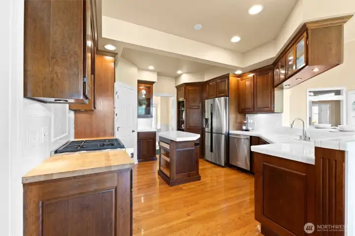 Kitchen with island, stainless steel appliances and Wolf cooktop, oven and microwave.