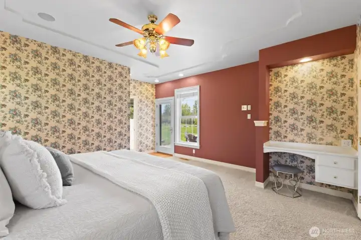Primary suite with backyard and mountain views with a built in desk/makeup vanity.