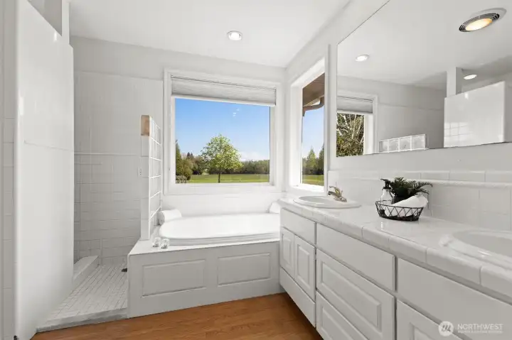 This primary bathroom features a shower, soaking tub, double sinks, separate toilet room and walk in closet (off camera on the left). The closet has automatic lighting triggered by opening the door.