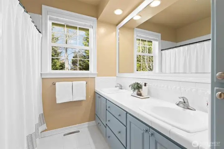 Secondary full bath. Toilet is next to tub enclosure (off camera to the left). Plenty of built in storage. Tile flooring.
