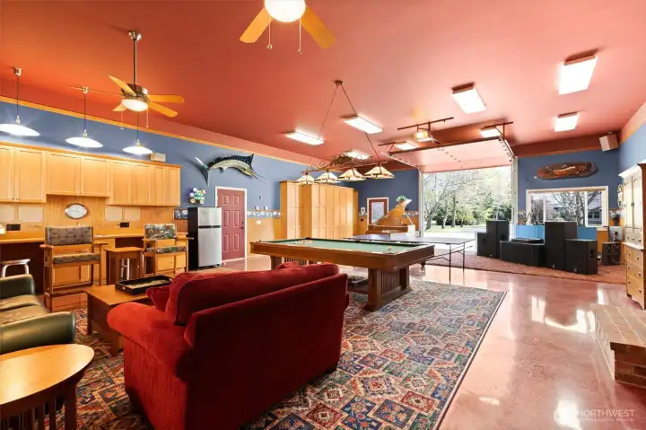 GAME ROOM! The garage door makes it easy to absorb lots of guests during warm season parties. Notice the strategic painting which makes the garage door and it's hardware blend into the ceiling. Kitchen sink and abundant cabinet storage. Red door at center leads to ADU garage.