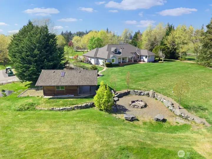 View of back yard, terraced fire pit and studio. The 30'x60' asphalt pad on the far left could be a sport court or accomodate a structure to cover an RV.