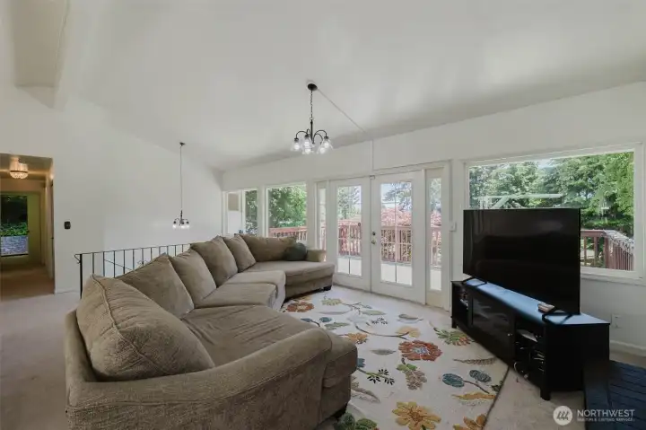 This light-filled living room features soaring ceilings, French doors, and oversized windows that frame breathtaking views of Dyes Inlet. The seamless connection to the outdoor deck creates the perfect space to relax and take in the peaceful scenery year-round. This light-filled living room features soaring ceilings, French doors, and oversized windows that frame breathtaking views of Dyes Inlet. The seamless connection to the outdoor deck creates the perfect space to relax and take in the peaceful scenery year-round.