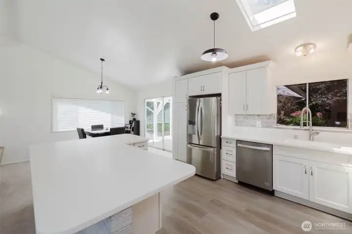 Clean lines, vaulted ceilings, and an oversized peninsula create a bright, open kitchen with plenty of prep space and seating. Clean lines, vaulted ceilings, and an oversized peninsula create a bright, open kitchen with plenty of prep space and seating.