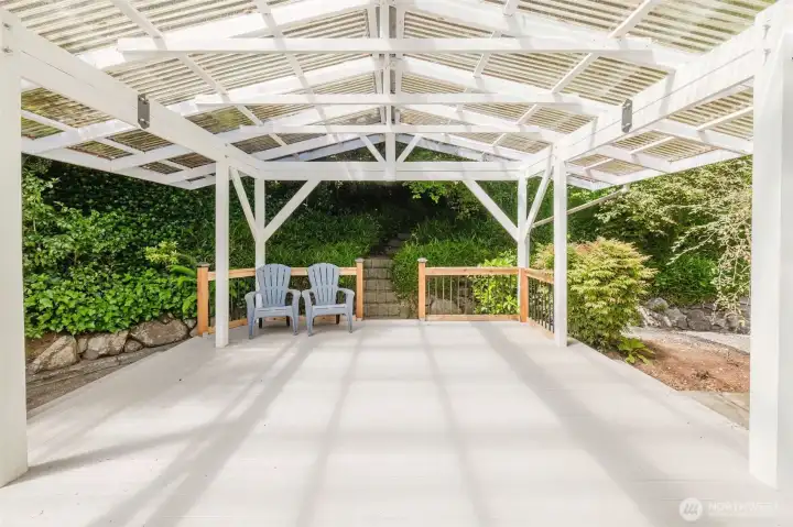 Covered outdoor entertaining area located just off the dining room creates the perfect extension of the living space for year-round enjoyment. A pathway and staircase lead to a large upper area with exciting potential for future expansion, additional outdoor living space, gardening opportunities, or ?? Covered outdoor entertaining area located just off the dining room creates the perfect extension of the living space for year-round enjoyment. A pathway and staircase lead to a large upper area with exciting potential for future expansion, additional outdoor living space, gardening opportunities, or ??