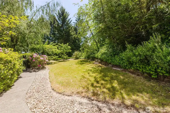 Spacious side yard surrounded by mature fruit trees and established landscaping offers a peaceful, park-like setting with plenty of room to relax, or entertain outdoors. Spacious side yard surrounded by mature fruit trees and established landscaping offers a peaceful, park-like setting with plenty of room to relax, or entertain outdoors.