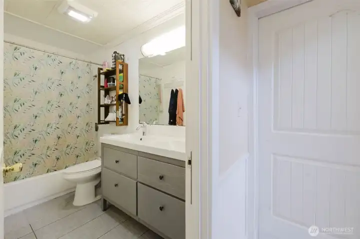 Lower-level bathroom has been thoughtfully refreshed with recent updates including a new vanity, toilet, tub surround, and stylish flooring for a clean, modern feel. Lower-level bathroom has been thoughtfully refreshed with recent updates including a new vanity, toilet, tub surround, and stylish flooring for a clean, modern feel.
