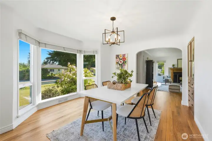 Dining room opens to living room and kitchen with lots of windows and natural light