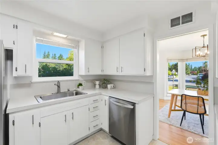 Kitchen opens up to dining room and has side entry to driveway and garage access