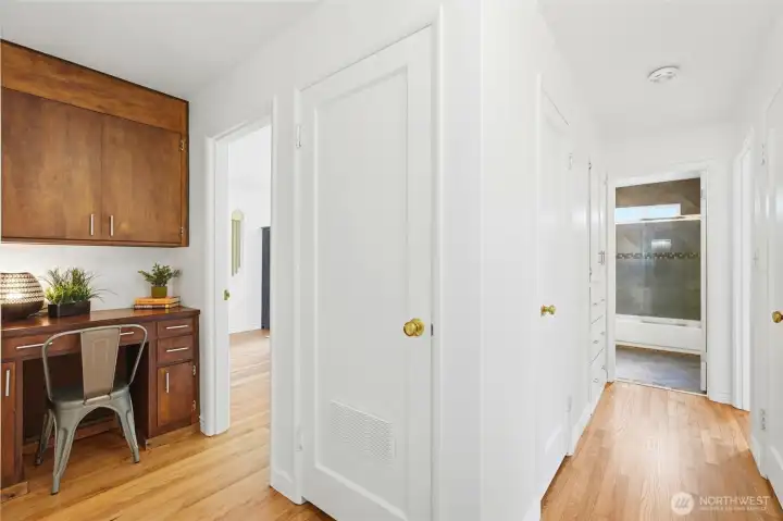 Hallway leads to built-in desk and living room, or down hall to 2 bedrooms and bath