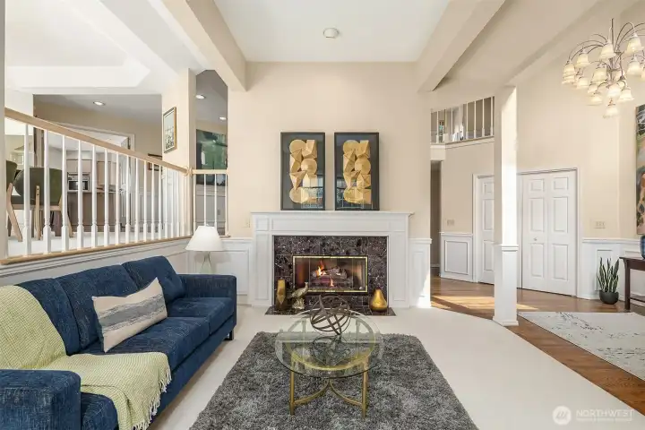 The formal living room is anchored by a beautiful gas fireplace with a classic mantel and marble surround, while floor-to-ceiling windows flood the space with an abundance of natural light. The formal living room is anchored by a beautiful gas fireplace with a classic mantel and marble surround, while floor-to-ceiling windows flood the space with an abundance of natural light.